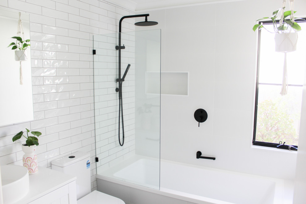 Design ideas for a mid-sized 3/4 bathroom in Perth with shaker cabinets, white cabinets, a drop-in tub, a shower/bathtub combo, a one-piece toilet, white tile, ceramic tile, white walls, porcelain floors, a vessel sink, engineered quartz benchtops, grey floor, an open shower, white benchtops, a shower seat, a single vanity and a floating vanity.