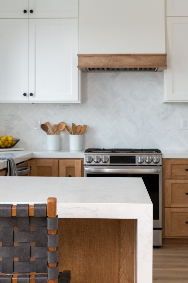 Design ideas for a small transitional l-shaped kitchen in Orange County with a single-bowl sink, shaker cabinets, white cabinets, quartzite benchtops, white splashback, marble splashback, stainless steel appliances, vinyl floors, a peninsula, brown floor and white benchtop.