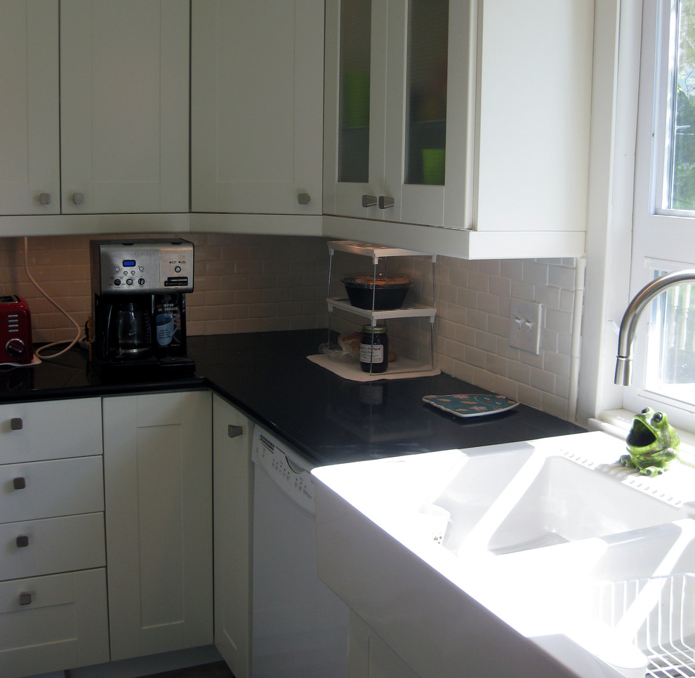 Example of a transitional u-shaped eat-in kitchen design in Milwaukee with a farmhouse sink, recessed-panel cabinets, white cabinets, quartz countertops, white backsplash, subway tile backsplash and white appliances
