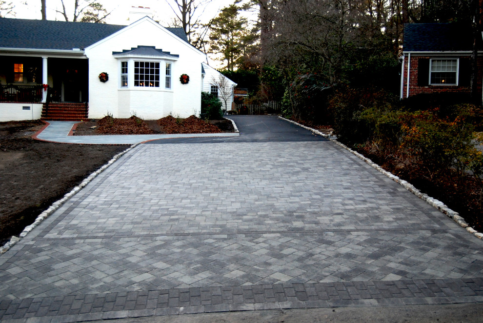 This is an example of a mid-sized traditional front yard full sun driveway for summer in Richmond with brick pavers.