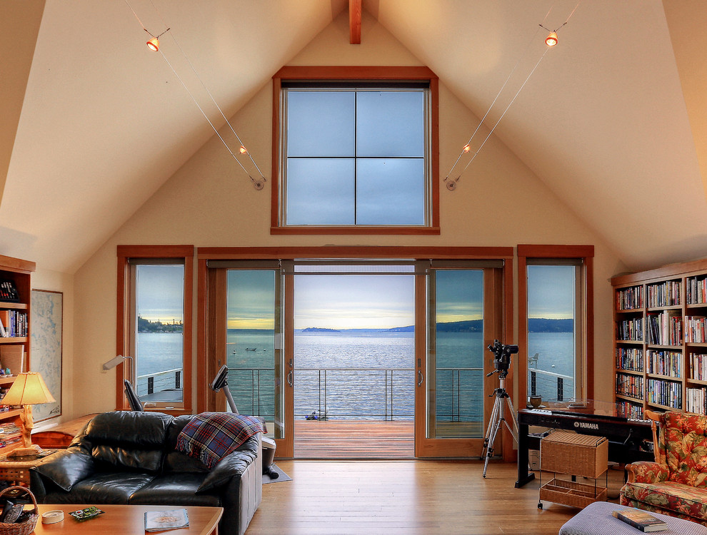 Inspiration for a large beach style open concept family room in Seattle with a library, white walls, light hardwood floors, no tv, brown floor and vaulted.