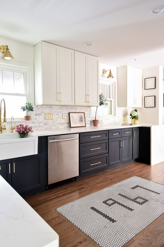Inspiration for a transitional u-shaped medium tone wood floor and brown floor kitchen remodel with a farmhouse sink, recessed-panel cabinets, black cabinets, white backsplash, stainless steel appliances and white countertops