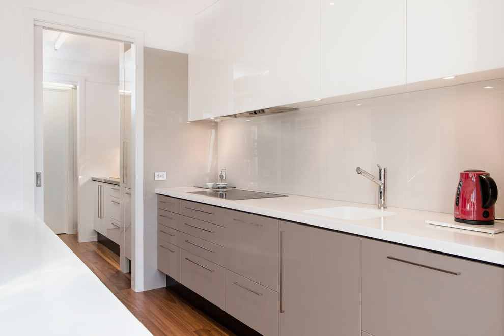 Design ideas for a large contemporary galley eat-in kitchen in Melbourne with white cabinets, glass sheet splashback and with island.