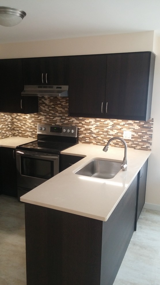 Photo of a small traditional u-shaped eat-in kitchen in Toronto with an undermount sink, flat-panel cabinets, dark wood cabinets, quartz benchtops, multi-coloured splashback, mosaic tile splashback, stainless steel appliances, vinyl floors and a peninsula.