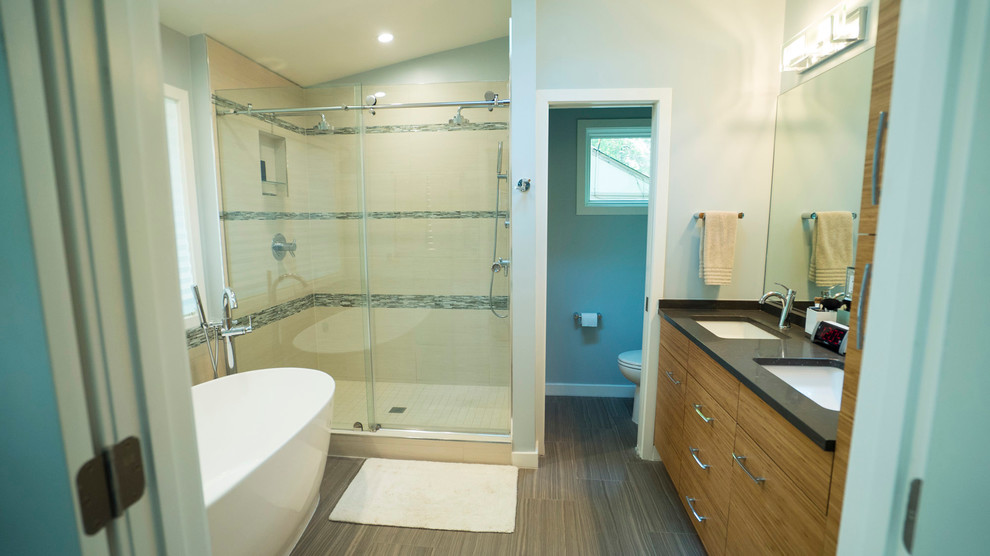 Small contemporary master bathroom in DC Metro with flat-panel cabinets, dark wood cabinets, a freestanding tub, an alcove shower, multi-coloured tile, ceramic tile, light hardwood floors, an undermount sink and granite benchtops.