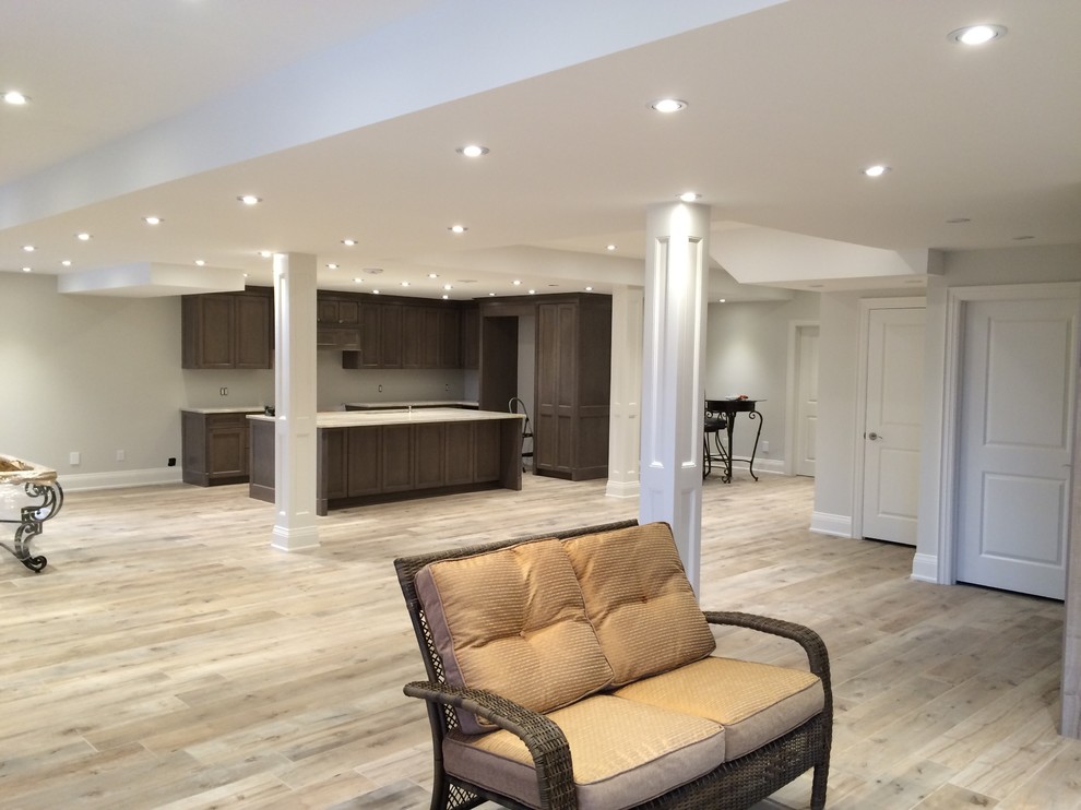 Inspiration for a large transitional fully buried basement in Toronto with grey walls, light hardwood floors, no fireplace and beige floor.