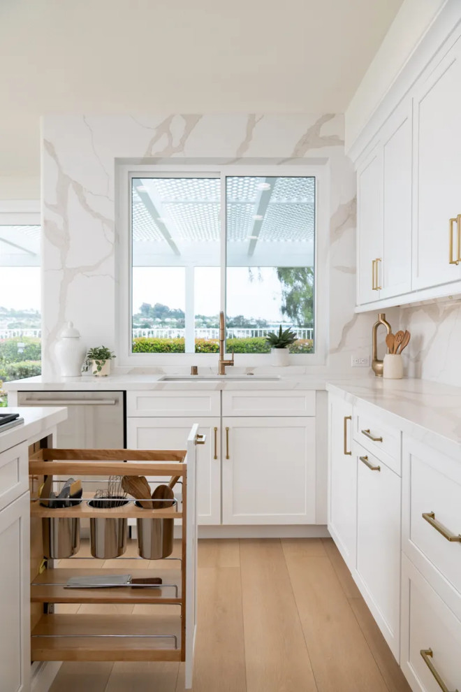 Eat-in kitchen - transitional u-shaped vinyl floor and brown floor eat-in kitchen idea in Orange County with an undermount sink, shaker cabinets, white cabinets, quartz countertops, white backsplash, quartz backsplash, stainless steel appliances, an island and white countertops