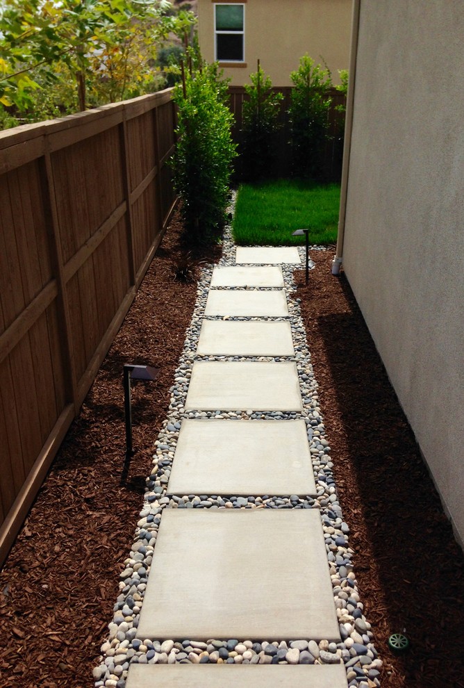 Inspiration for a mid-sized modern backyard full sun xeriscape in San Diego with a garden path and mulch.