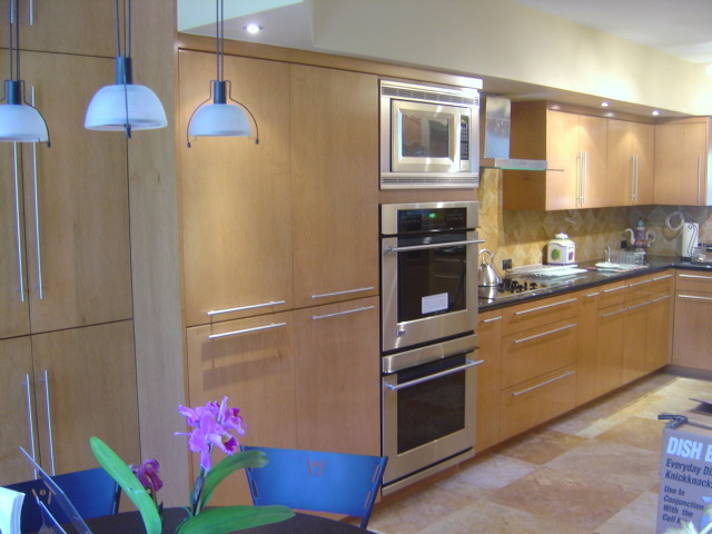 Eat-in kitchen - mid-sized transitional l-shaped travertine floor eat-in kitchen idea in Miami with flat-panel cabinets, light wood cabinets, solid surface countertops, yellow backsplash, ceramic backsplash and stainless steel appliances
