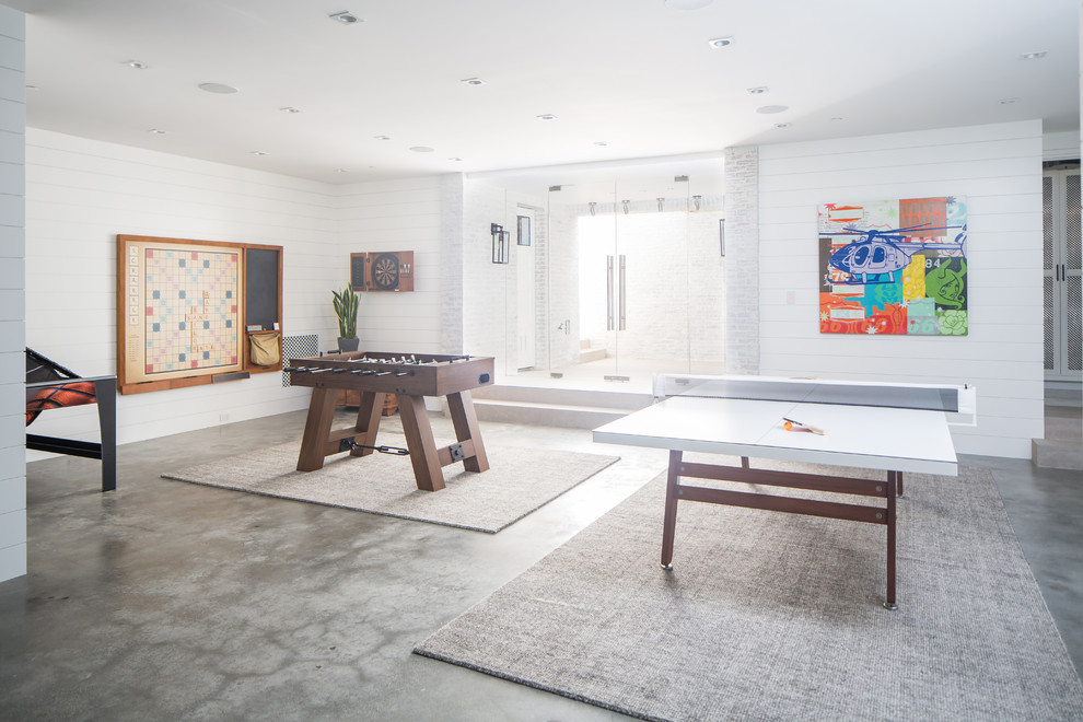 Inspiration for a beach style enclosed family room in Orange County with a game room, white walls, concrete floors and grey floor.