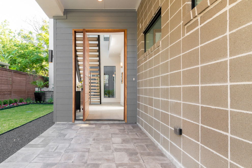 Esempio di una grande porta d'ingresso moderna con pareti grigie, pavimento con piastrelle in ceramica, una porta a pivot, una porta in legno chiaro, pavimento beige e pareti in mattoni