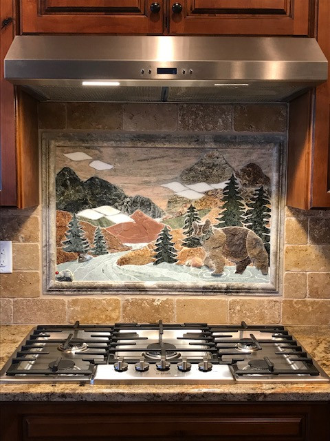Eat-in kitchen - large rustic single-wall eat-in kitchen idea in Denver with raised-panel cabinets, brown cabinets, granite countertops, multicolored backsplash, travertine backsplash and multicolored countertops