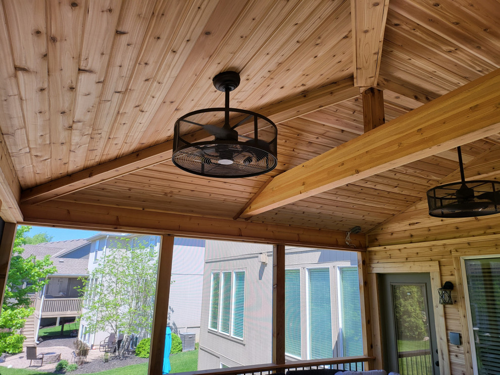 Réalisation d'un porche d'entrée de maison arrière chalet de taille moyenne avec une moustiquaire, une extension de toiture et un garde-corps en matériaux mixtes.