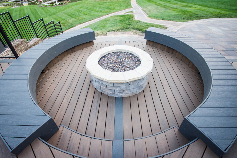 Example of a large transitional backyard deck design with a fire pit and no cover