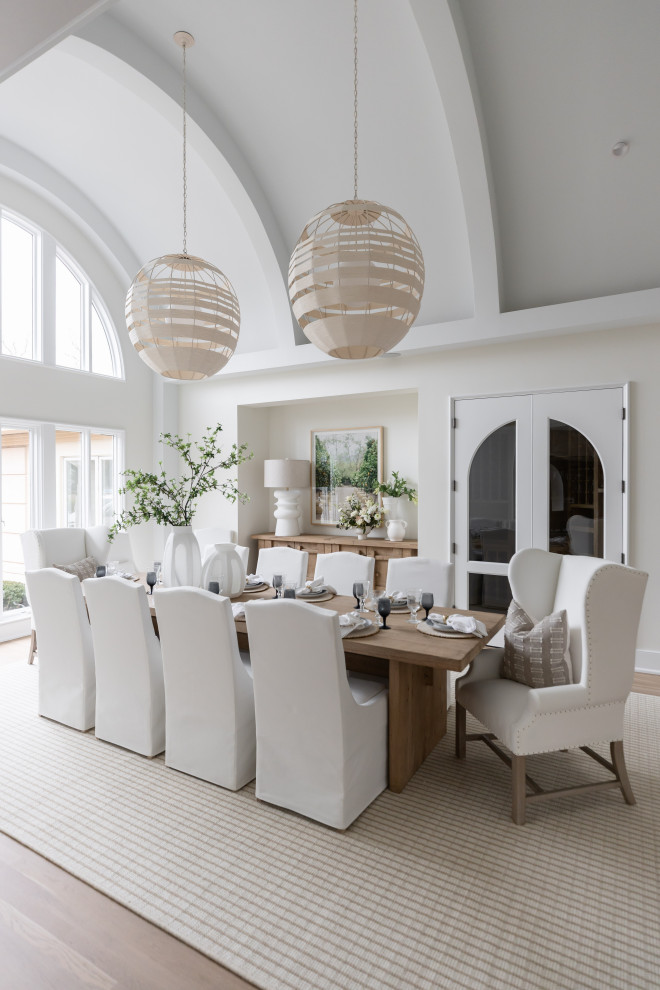 Dining room - large coastal medium tone wood floor, brown floor and vaulted ceiling dining room idea in Nashville with white walls