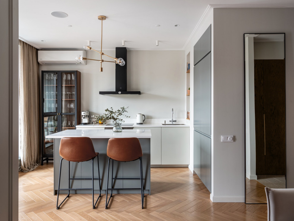 Foto di una cucina design con lavello sottopiano, ante lisce, pavimento in legno massello medio e pavimento beige