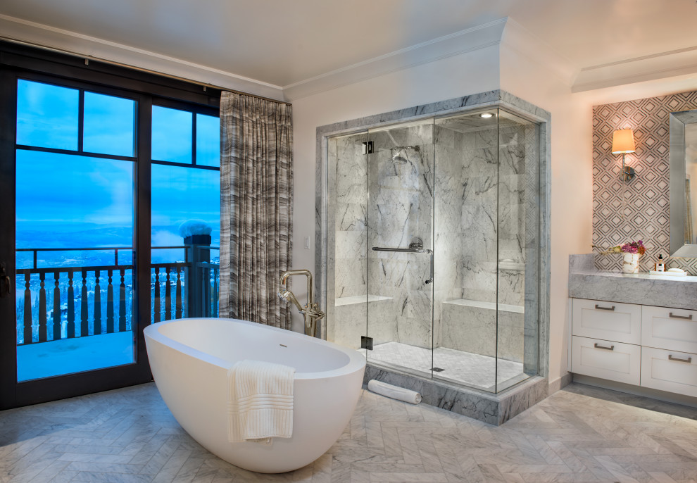 Expansive contemporary master bathroom in Salt Lake City with white cabinets, a freestanding tub, an open shower, white tile, stone tile, marble floors, an undermount sink, marble benchtops, white floor, a hinged shower door, white benchtops, a shower seat, a double vanity and a built-in vanity.