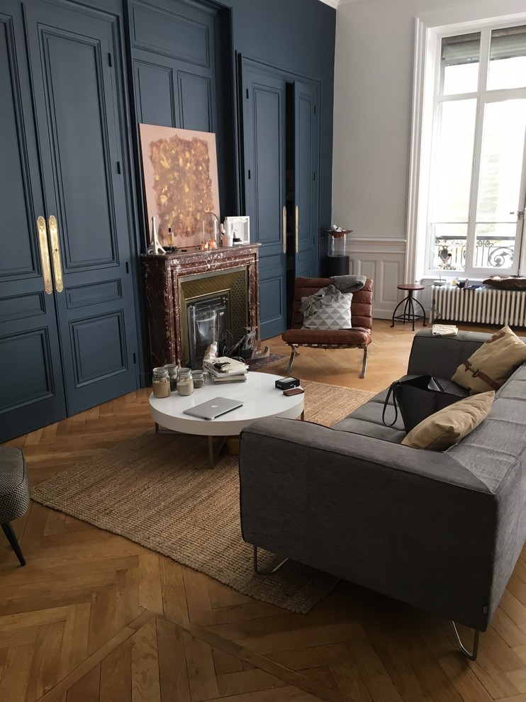 Inspiration for a mid-sized transitional enclosed family room in Lyon with blue walls, medium hardwood floors and no fireplace.