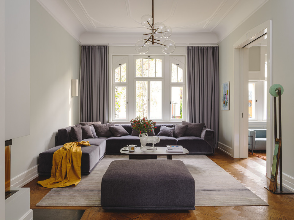 Großes, Offenes Klassisches Wohnzimmer mit braunem Holzboden, Kaminofen, Kaminumrandung aus Metall und TV-Wand in Frankfurt am Main