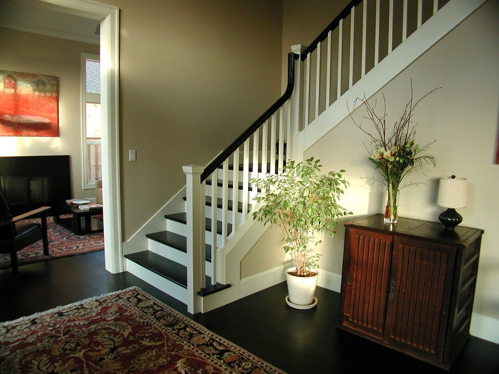 Photo of a large transitional wood l-shaped staircase in Portland with painted wood risers and wood railing.