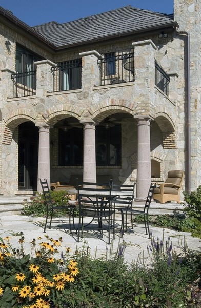 Inspiration for a large mediterranean two-storey beige exterior in Chicago with stone veneer and a gable roof.