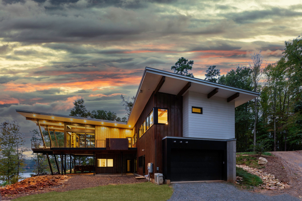 На фото: двухэтажный, разноцветный частный загородный дом среднего размера в стиле модернизм с облицовкой из металла, крышей-бабочкой, металлической крышей, серой крышей и отделкой доской с нащельником с