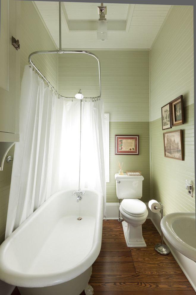 This is an example of a traditional bathroom in Austin with a claw-foot tub, a shower/bathtub combo and green walls.