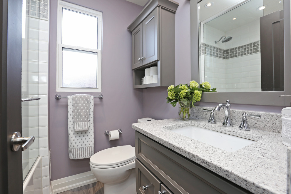 Small transitional kids bathroom in Toronto with grey cabinets, an alcove tub, a shower/bathtub combo, a one-piece toilet, white tile, purple walls and an undermount sink.