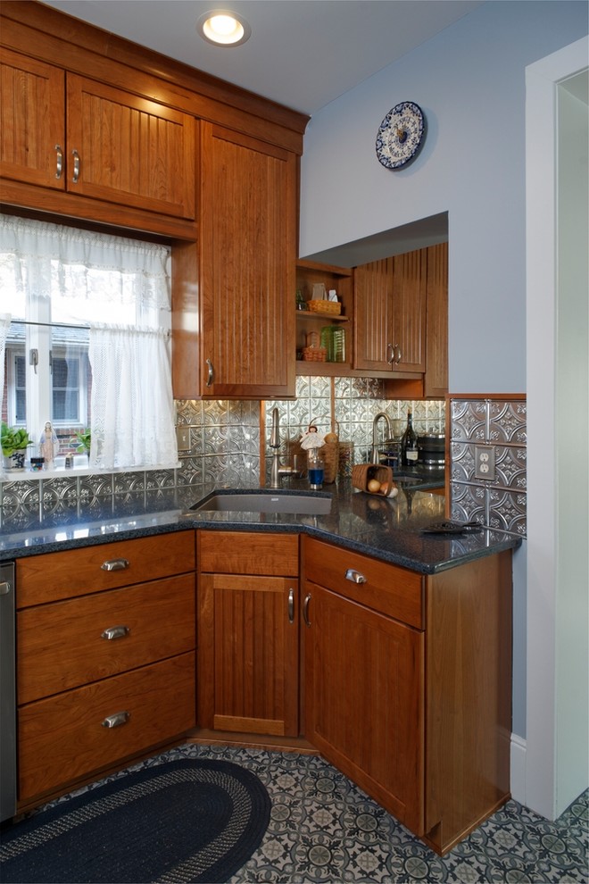 Photo of a small country u-shaped separate kitchen in Philadelphia with an undermount sink, recessed-panel cabinets, medium wood cabinets, quartz benchtops, metallic splashback, metal splashback, stainless steel appliances, porcelain floors and multi-coloured floor.