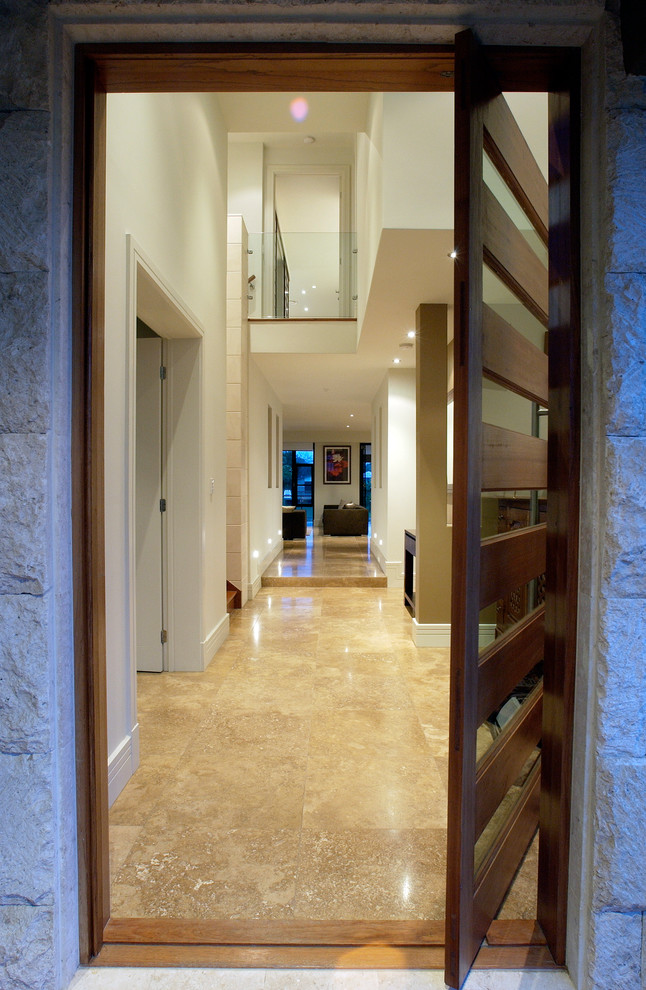 Photo of a mid-sized asian front door in Brisbane with beige walls, travertine floors, a single front door, a dark wood front door and beige floor.