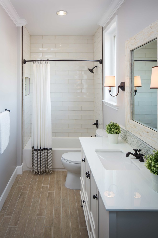 Large transitional bathroom in Los Angeles with an undermount sink, white cabinets, stone tile, grey walls, an alcove tub, white tile, a shower/bathtub combo and recessed-panel cabinets.