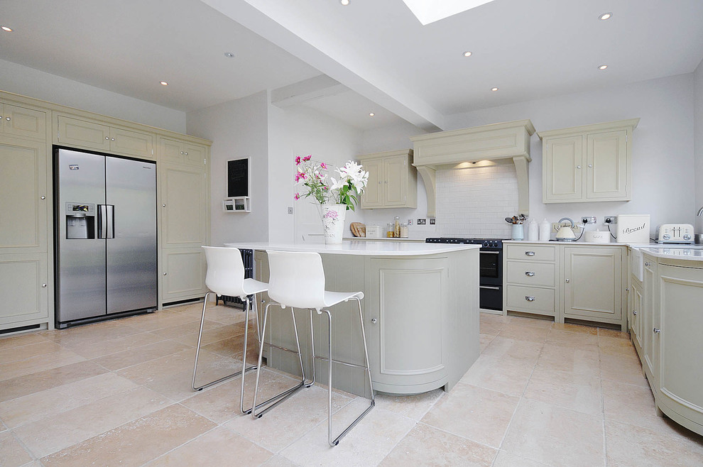 Mid-sized traditional kitchen in Surrey with a farmhouse sink, recessed-panel cabinets, quartz benchtops, white splashback, subway tile splashback, porcelain floors, with island, stainless steel appliances and beige floor.