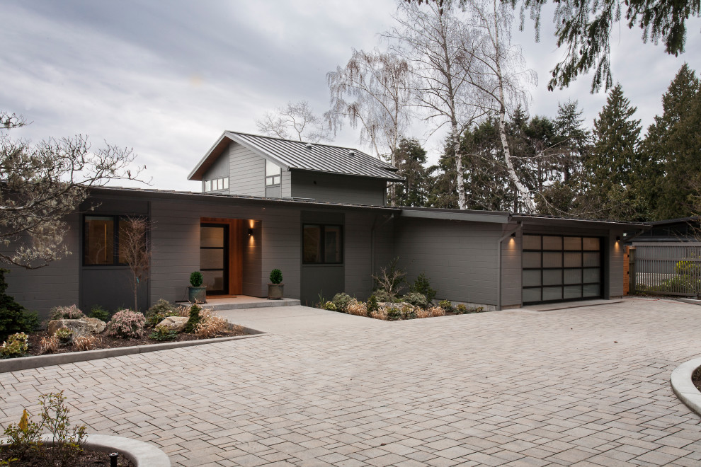 Modelo de fachada de casa gris y negra contemporánea grande de dos plantas con tejado de metal, tejado de un solo tendido, revestimiento de aglomerado de cemento y panel y listón