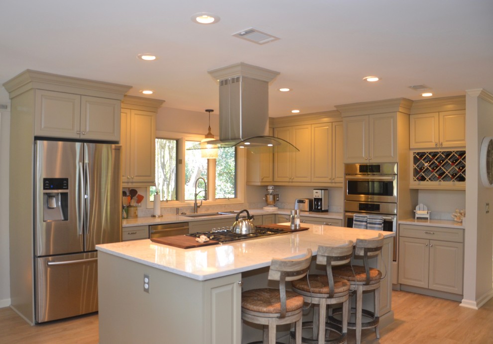 Example of a mid-sized transitional l-shaped vinyl floor eat-in kitchen design in Atlanta with raised-panel cabinets, quartz countertops, stainless steel appliances and an island