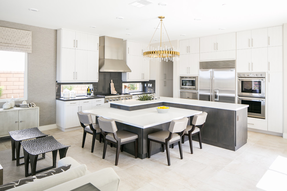 Contemporary l-shaped open plan kitchen in San Diego with white cabinets, quartzite benchtops, black splashback, stainless steel appliances, with island and white benchtop.