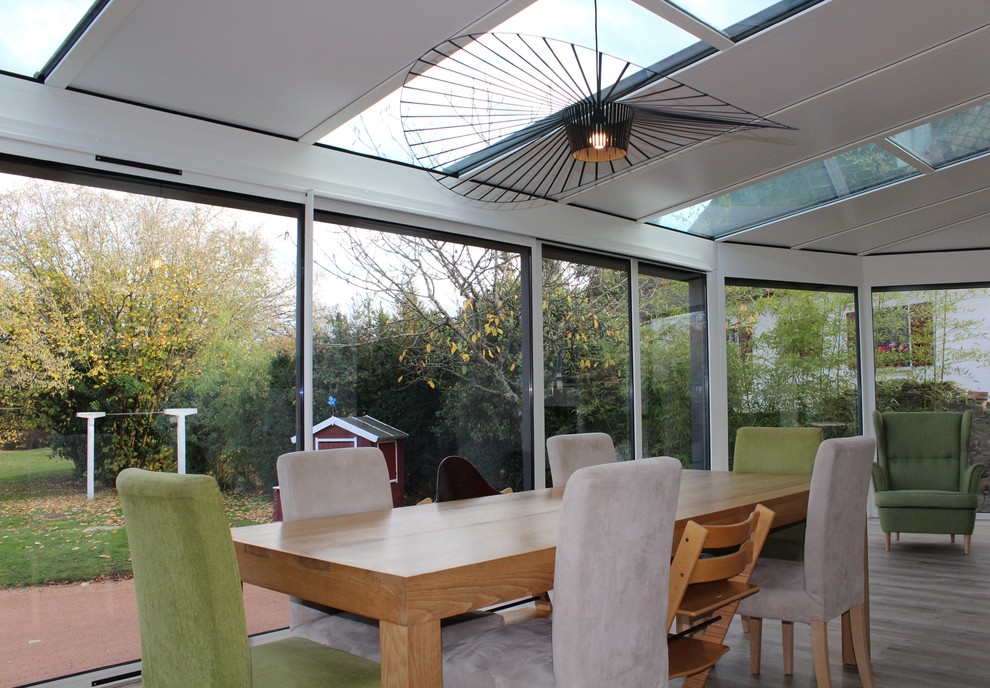 Design ideas for a mid-sized scandinavian sunroom in Clermont-Ferrand with laminate floors, a skylight and brown floor.