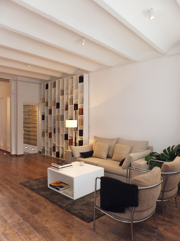 Photo of a mid-sized contemporary open concept living room in Barcelona with white walls, dark hardwood floors, a library, no fireplace and no tv.