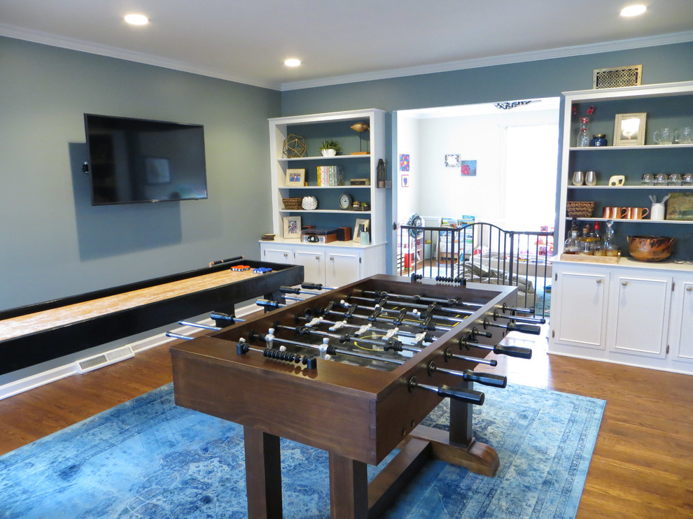 Large country enclosed family room in Chicago with a game room, blue walls, medium hardwood floors, no fireplace and a wall-mounted tv.