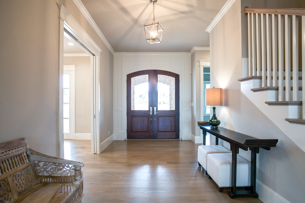 Design ideas for a large traditional foyer in Dallas with grey walls, light hardwood floors, a double front door and a dark wood front door.