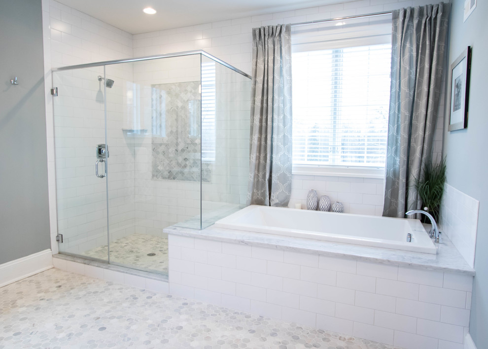 Photo of a mid-sized transitional master bathroom in Philadelphia with shaker cabinets, white cabinets, a drop-in tub, a corner shower, grey walls, pebble tile floors and an undermount sink.