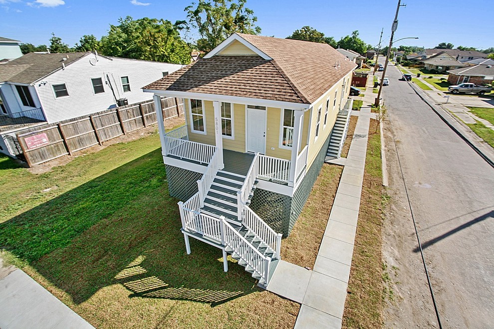 Mid-sized traditional one-storey concrete yellow exterior in New Orleans with a gable roof.