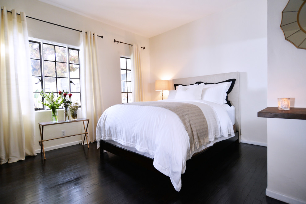Inspiration for a small industrial master bedroom in Los Angeles with white walls, dark hardwood floors and black floor.