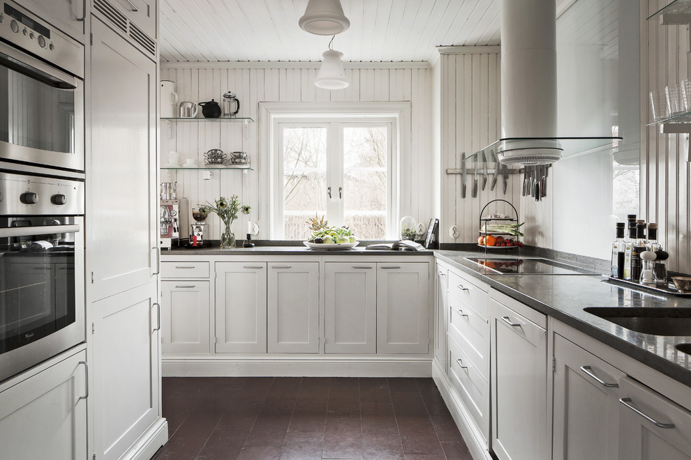 Mid-sized scandinavian l-shaped kitchen in Stockholm with an undermount sink, shaker cabinets, white cabinets, no island, concrete benchtops, stainless steel appliances and limestone floors.