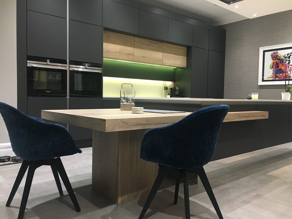 Inspiration for a medium sized contemporary single-wall open plan kitchen with an integrated sink, flat-panel cabinets, composite countertops, black appliances and an island.