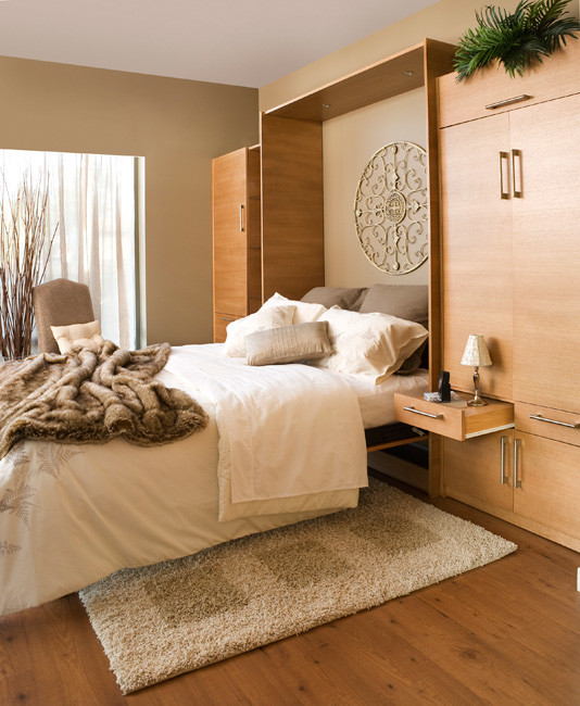 Design ideas for a large contemporary guest bedroom in Orange County with beige walls, light hardwood floors and no fireplace.
