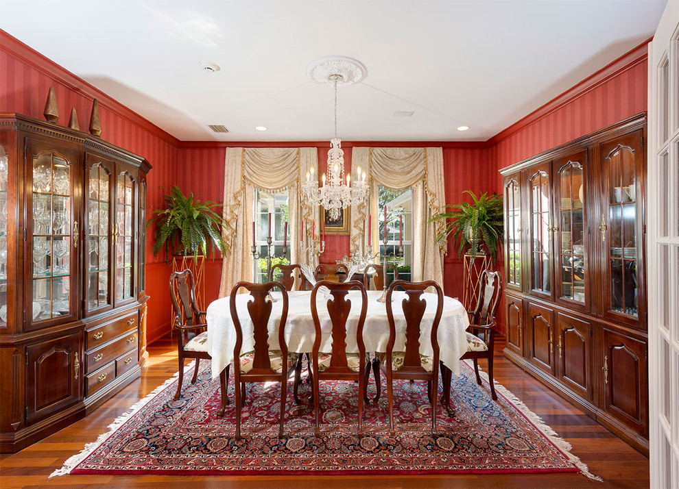 Inspiration for a mid-sized traditional separate dining room in Other with red walls, medium hardwood floors, no fireplace and brown floor.