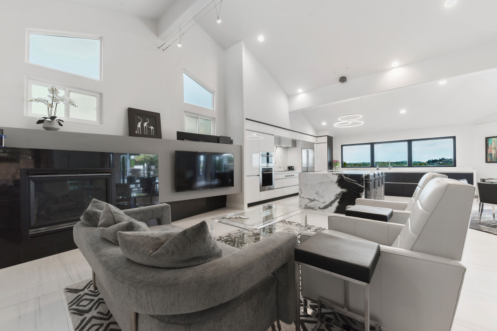 Mid-sized contemporary eat-in kitchen in Orange County with an undermount sink, flat-panel cabinets, black cabinets, marble benchtops, marble splashback, stainless steel appliances, porcelain floors, with island, white floor and exposed beam.