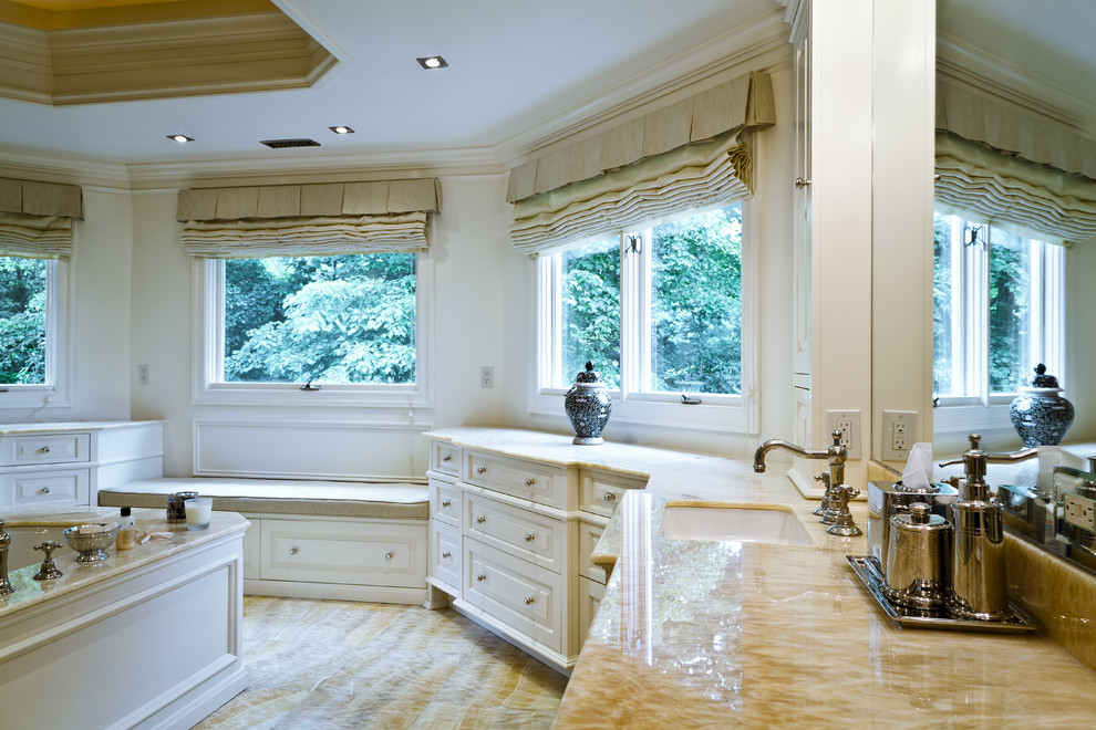 Inspiration for a mid-sized timeless master light wood floor corner shower remodel in New York with an undermount sink, raised-panel cabinets, white cabinets, marble countertops, an undermount tub, a one-piece toilet and white walls