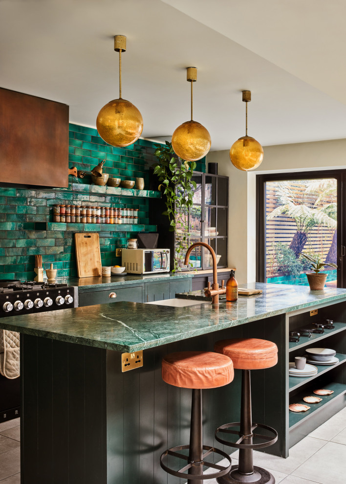 Inspiration for a medium sized traditional single-wall kitchen/diner in London with a built-in sink, glass-front cabinets, black cabinets, marble worktops, green splashback, ceramic splashback, integrated appliances, ceramic flooring, an island, grey floors, green worktops and feature lighting.