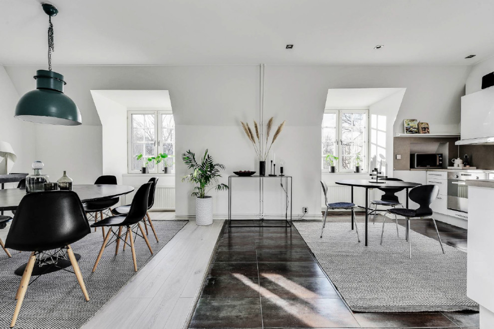 This is an example of a scandinavian dining room in Stockholm with white walls and grey floor.